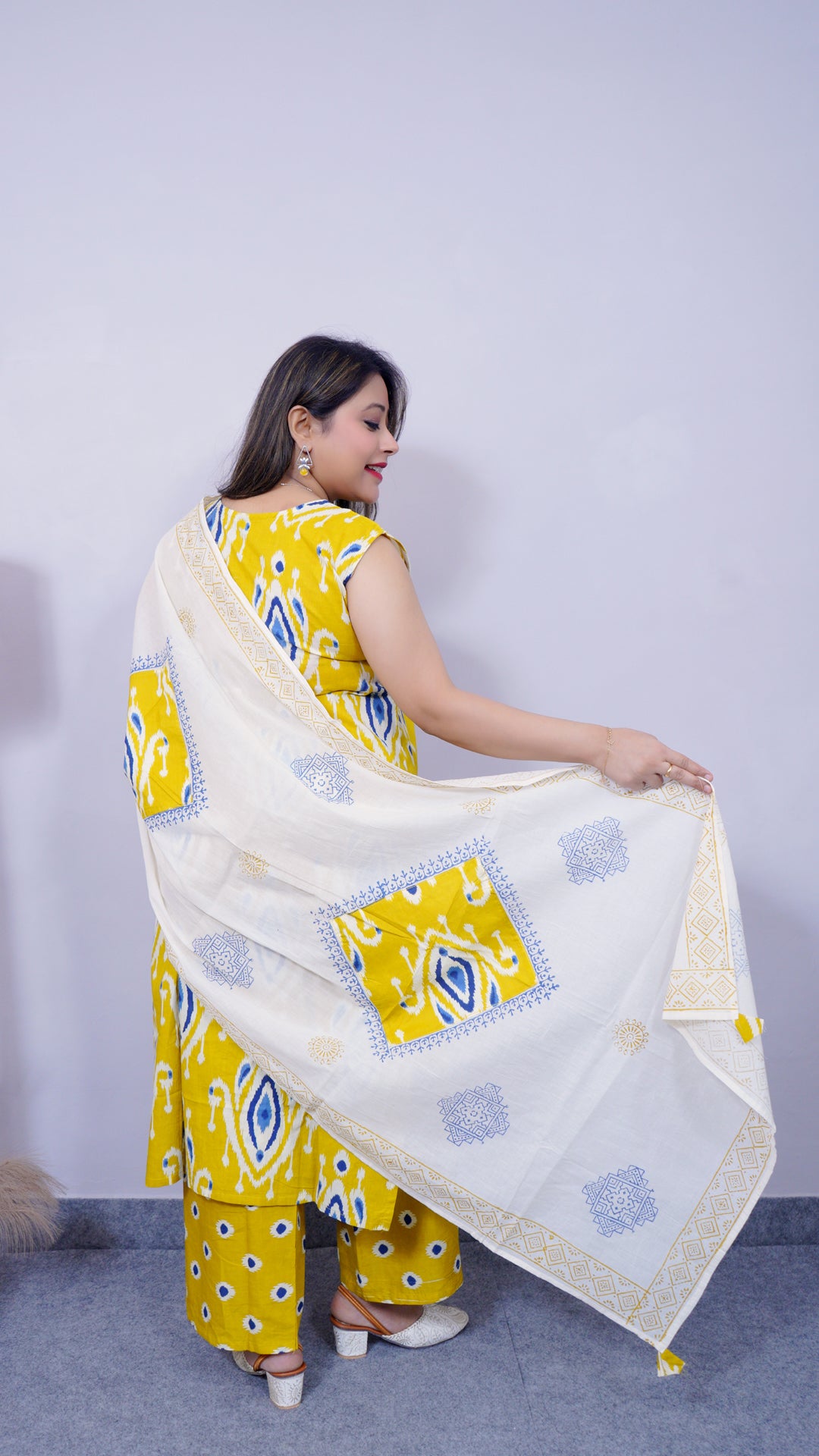 Back view of yellow-white ikat print cotton suit set with dhupatta for women